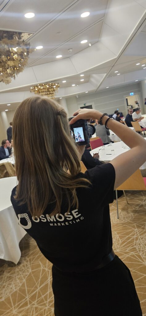 Collaboratrice d'Osmose Marketing photographiant un événement en salle
