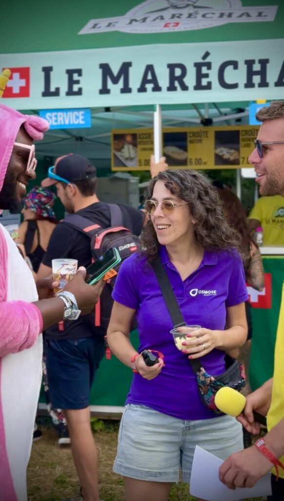 Collaboratrice d'Osmose Marketing devant un stand du Paléo Festival